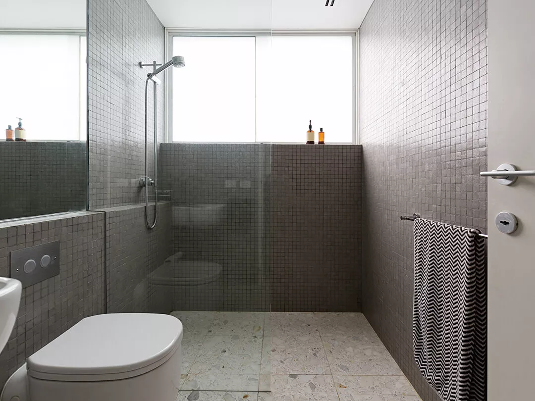 Walk-in-Dusche bodeneben mit einem Glaselement an der Wand befestigt