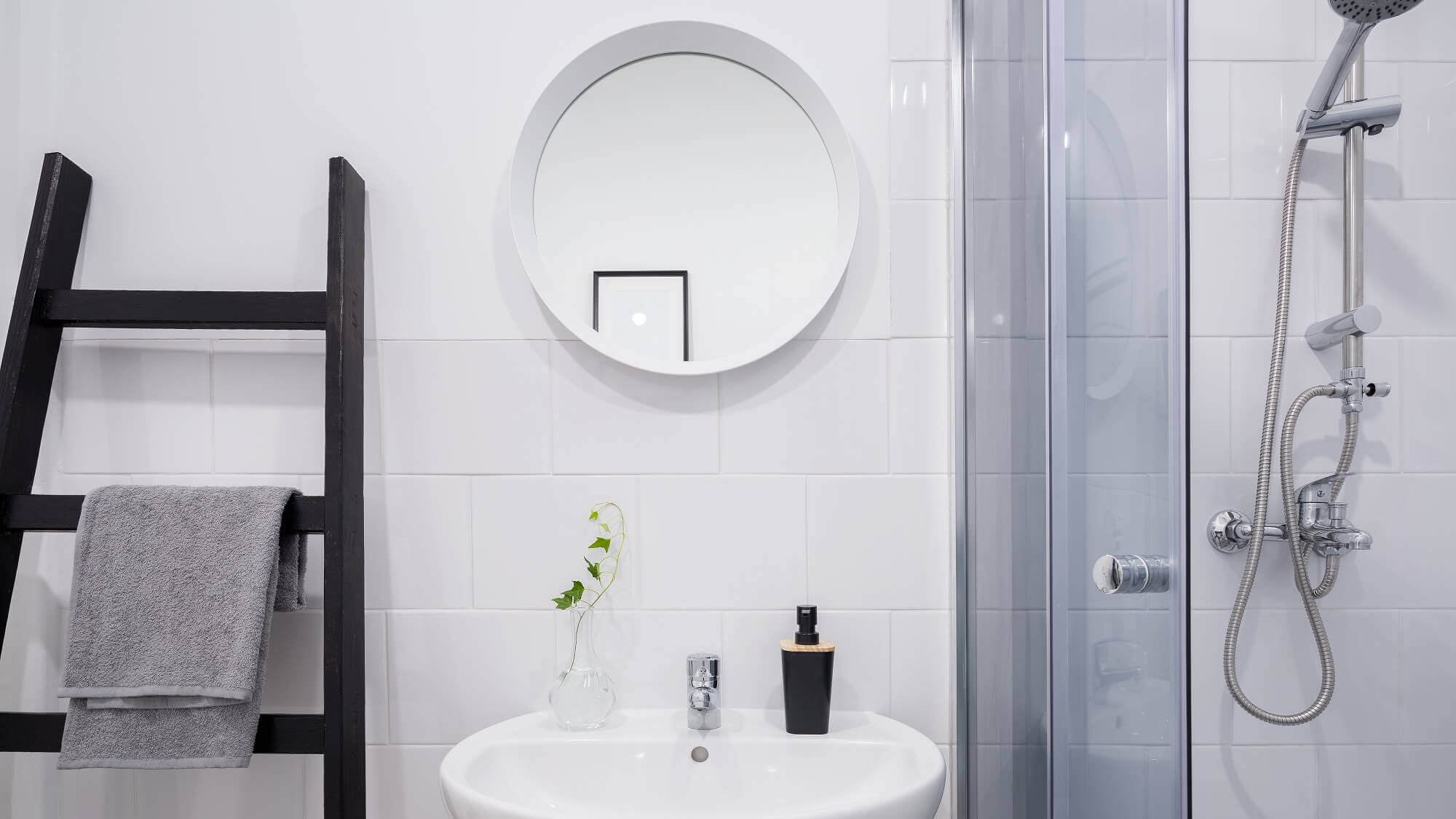 Kleines Badzimmer mit Leiter Waschbecken Spiegel und Dusche