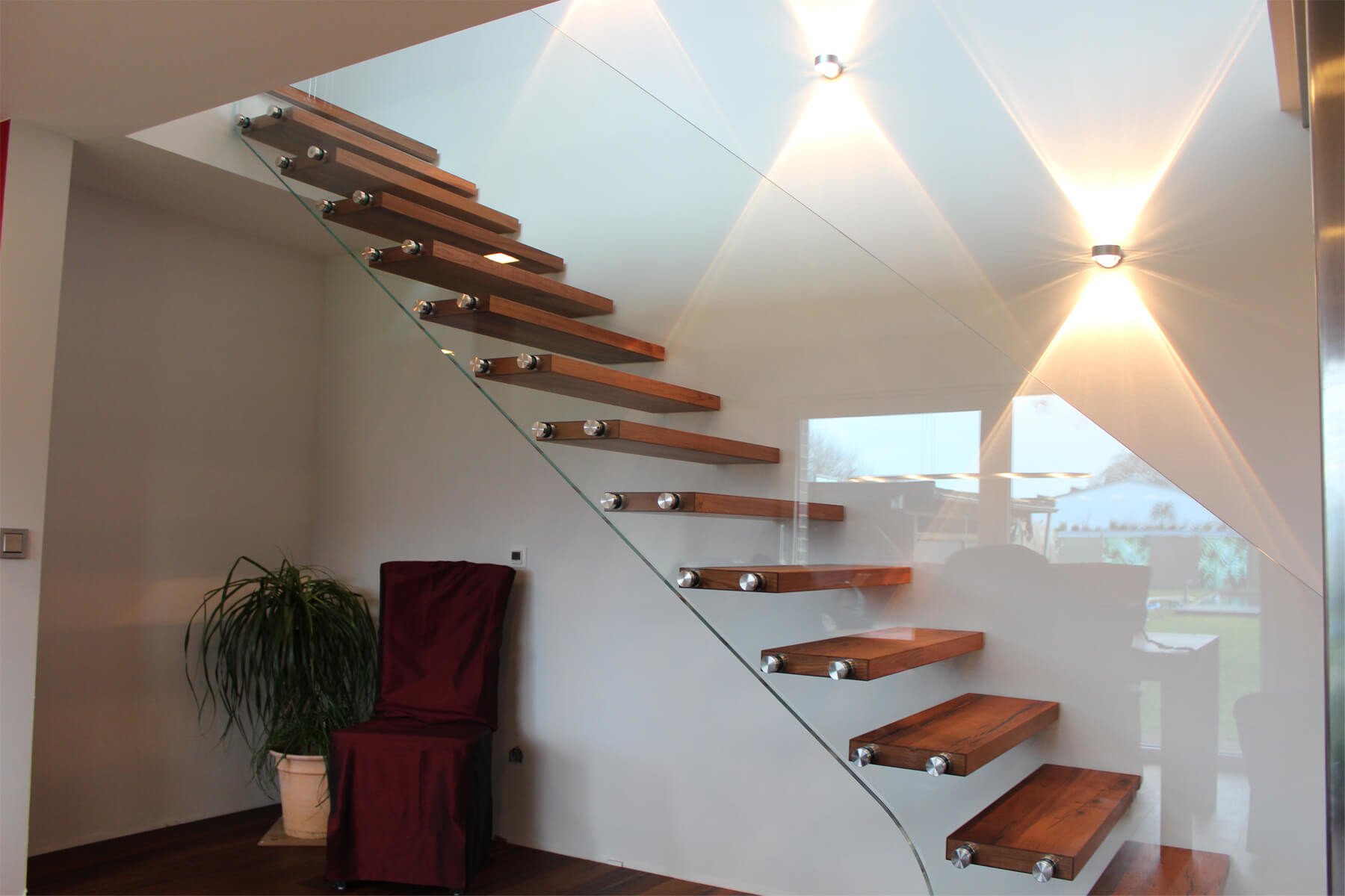 Absturzsichernde Glastrennwand im hellen Flur an Holztreppen