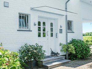 Freitragendes Glasvordach über dem Hauseinang