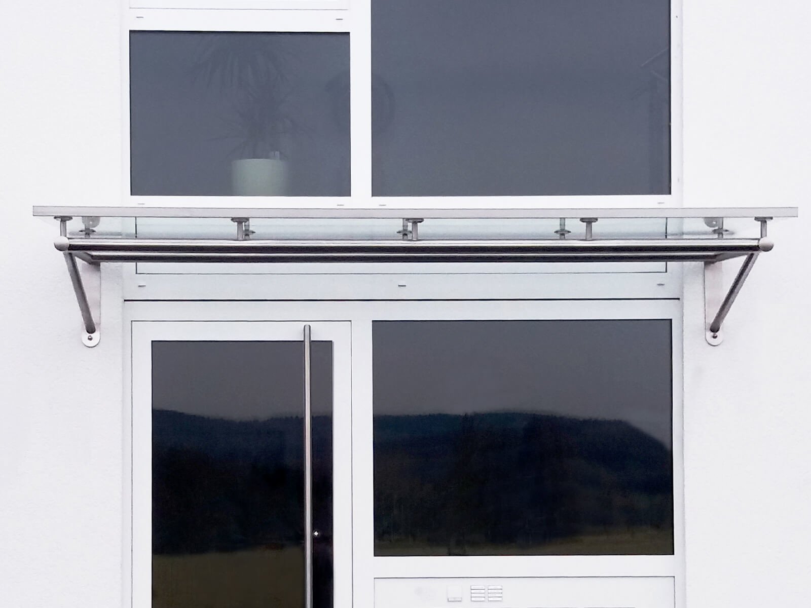 Glas Vordach Trave an Wärmedämmfassade