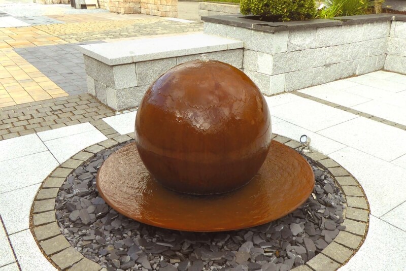 Kugelbrunnen mit Schale aus Cortenstahl auf Bruchsteinbeet