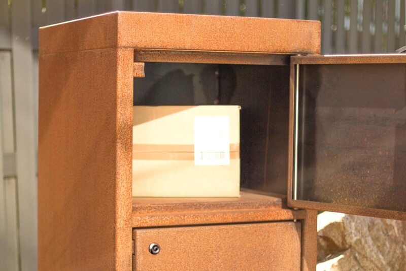 Paketbox gelagert in Fach aus Cortenstahl mit geöffneter Tür