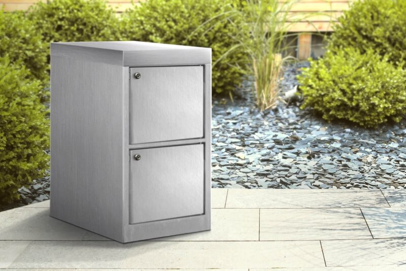 Paketbox mit zwei geschlossenen Türen aus Edelstahl vor Haustür