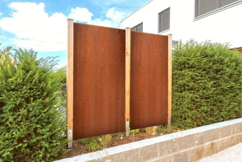 Sichtschutz für den Garten aus Cortenstahl mit passenden Pfosten im Boden befestigt